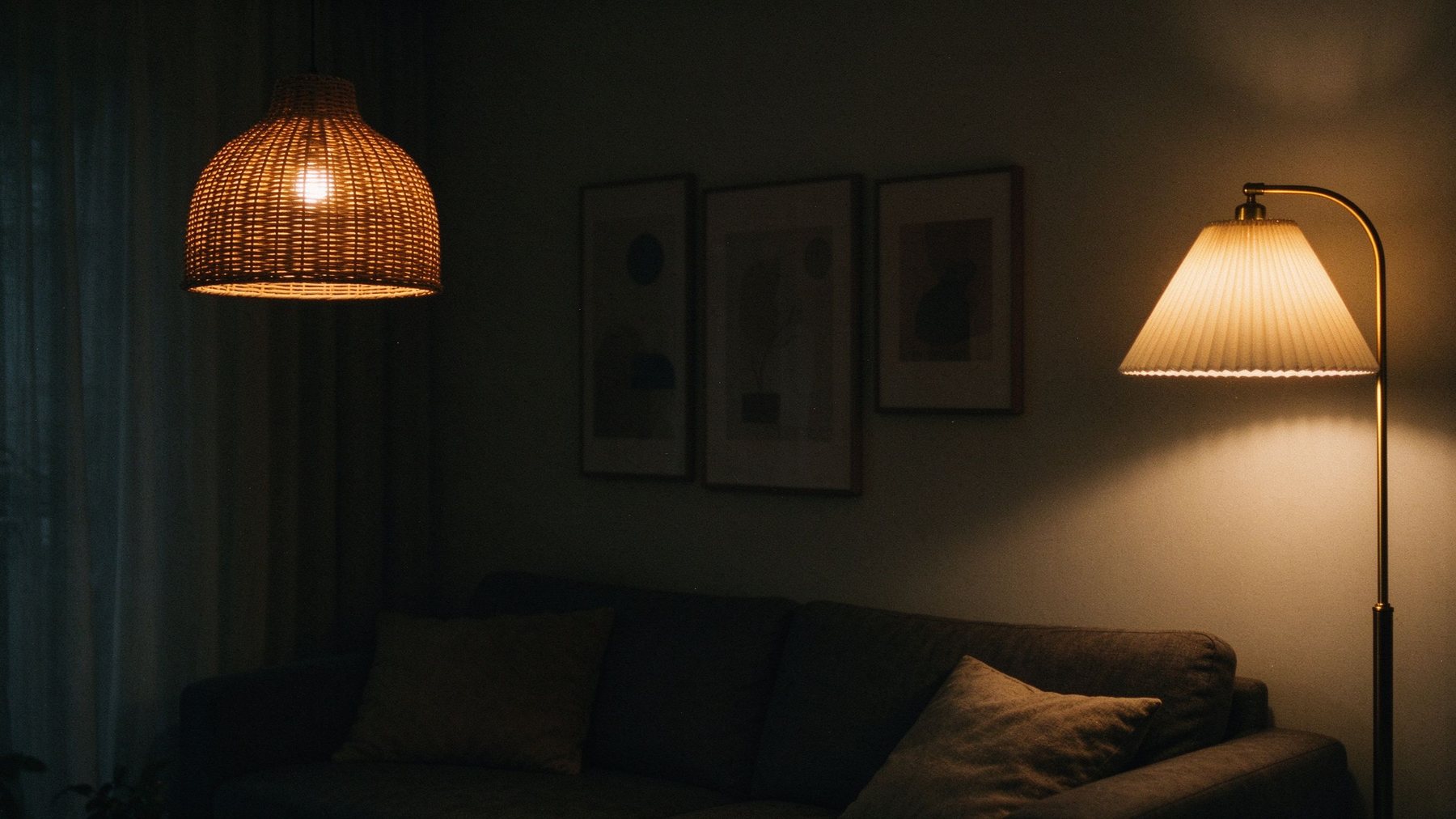 Dark living corner with glowing rattan pendant and brass floor lamp